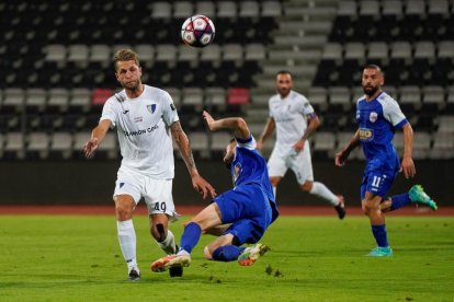 El lleidatà Adrià Gallego, de blanc, intenta controlar la pilota durant el partit.