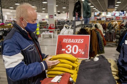 Un cliente mira varias prendas de ropa rebajadas ayer en el Wala. 