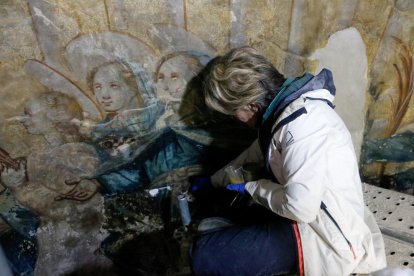 Treball de restauració en una de les imatges del mural.