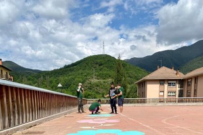 Los jóvenes pintando el circuito en la plaza de los Carantos. 