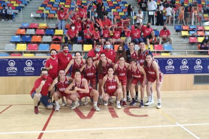 La plantilla del CB Lleida celebra su victoria junto al grupo de aficionados desplazados a Vic.