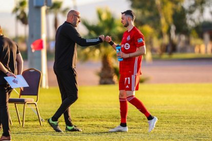 Enric Bernat se saluda con un miembro del cuerpo técnico del equipo canadiense.