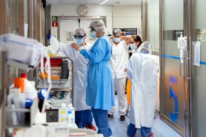 Enfermeras se preparan para entrar a una UCI de paciente Covid.