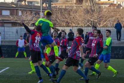 Un jugador del Martinenc remata de cabeza un centro en el área del Tàrrega.