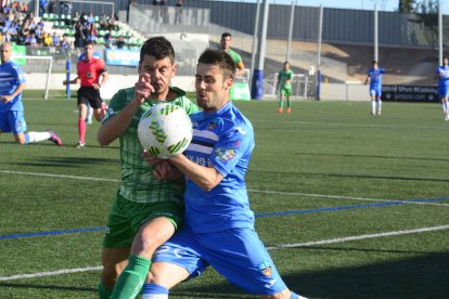 Dos jugadors lluiten per una pilota en una acció del partit d’ahir a Cornellà.