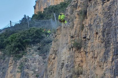 Los operarios haciendo mediciones para comprobar los movimientos de la montaña donde se produjo el desprendimiento. 