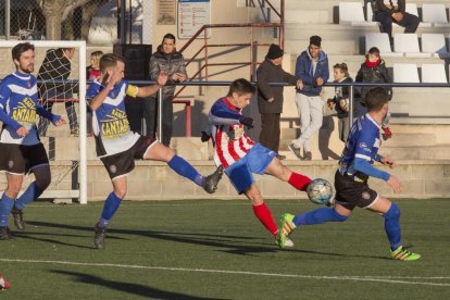 Un jugador del Agramunt golpea el balón ante la presión de dos jugadores visitantes