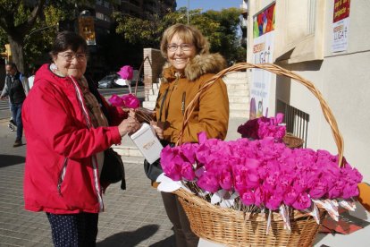 Una mujer colabora ayer con la iniciativa ‘Una flor per a un projecte’ en la mesa de Ricard Viñes.