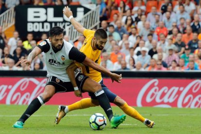 Garay y Carrasco luchan un balón durante el partido de ayer.