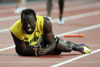 Usain Bolt, en el suelo después de sufrir la lesión que le impidió sumar una nueva medalla.