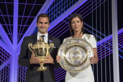 Roger Federer y Garbiñe Muguruza, con sus trofeos en la cena de campeones de Wimbledon.