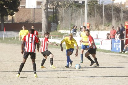 Un jugador del Castelldans intenta pasar entre dos jugadores del Bell-lloc.