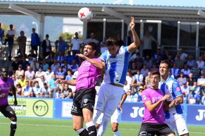 Andriu salta a buscar una pilota davant de la presència d’un jugador de l’At. Balears, en una acció del partit que el Lleida va jugar ahir a Son Malferit.