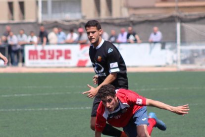 El local Galcerán pugna amb un adversari pel control de la pilota, en una acció del partit.