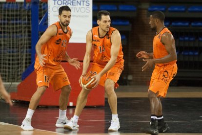 Miki Feliu, que ayer anotó 21 puntos, controla un balón apoyado por dos compañeros.
