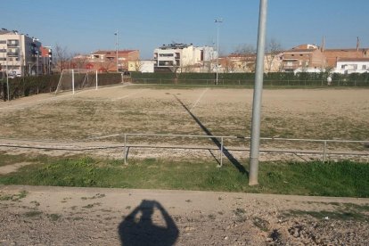 Estat del camp de futbol, amb males herbes a l’àrea de joc.