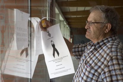 El concejal Josep Ortiz colgando carteles en los que se informaba del cierre en señal de luto.
