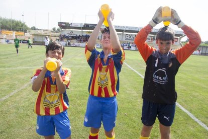 Jugadores del Bellpuig se refrescan tirándose agua por la cabeza antes de disputar un partido.