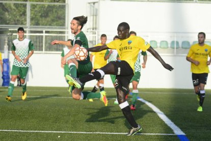 El centrocampista del Lleida, Mustapha, despeja el balón ante un jugador del Cerdanyola.