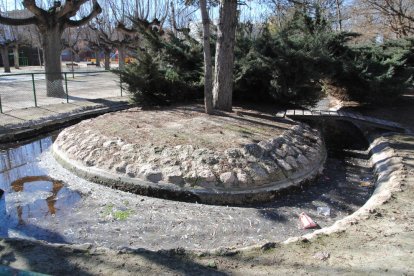 La balsa del parque municipal, con el agua sucia y escombros.