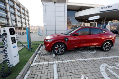 Imagen de un coche eléctrico en una estación de recarga a las puertas de un concesionario.