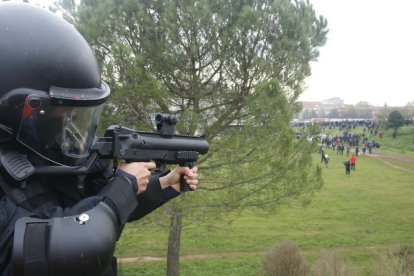 Un mosso apuntant amb una pistola de projectils de foam.