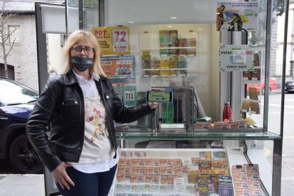 Ana Gras mostrando un boleto premiado con una fotografía a través del teléfono.