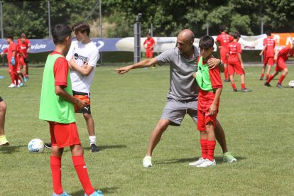 Pep Guardiola da instrucciones a uno de los participantes en el Pep Summer Camp.