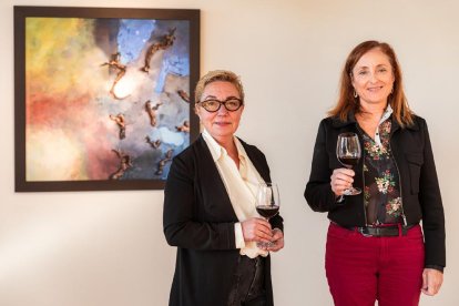 Maria Guinovart i Mireia Torres, al celler Jean Leon davant del quadre ‘Els ceps i la nit’ de Guinovart.