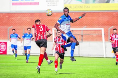 Un jugador del Mollerussa pugna amb un rival en una pilota aèria.