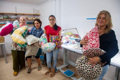 La gerent de Cartaes amb les encarregades de la confecció mostrant les creacions.