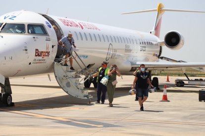 Passatgers del vol que va arribar a Alguaire des de Menorca ahir al migdia i, a la imatge de la dreta, demostració de drons a les instal·lacions de l’aeroport.