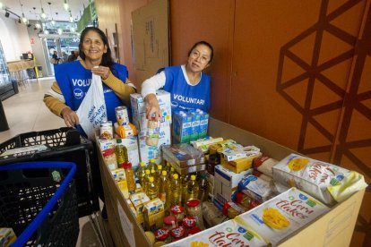 Dos voluntàries ahir en un supermercat de la Zona Alta de Lleida davant del material recaptat durant el matí.