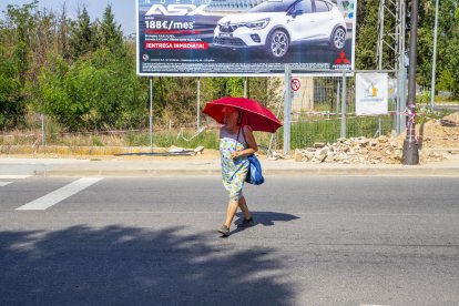 Una mujer se resguardaba ayer del sol con un paraguas en Lleida ciudad. 