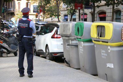 Un mosso, al costat del contenidor on es va trobar el tors.