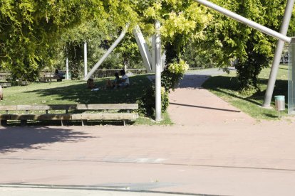 Dos joves es refugien del sol sota un arbre ahir en un parc de Lleida, que va arribar als 34ºC.