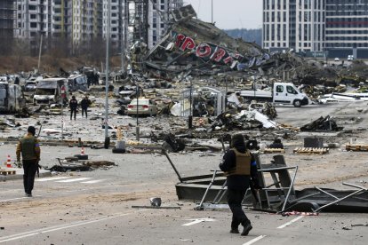 Miembros de la unidad de defensa territorial frente al centro comercial destruido en Kiev.