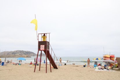 Un socorrista, junto a la bandera amarilla, en una playa de Catalunya.