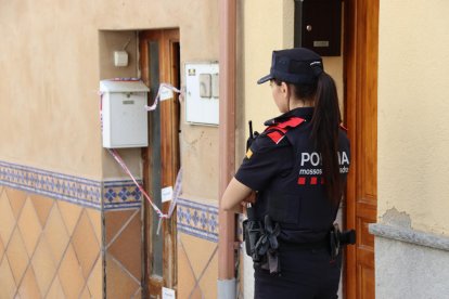 Una agent dels Mossos davant de la casa del presumpte assassí, que es troba precintada