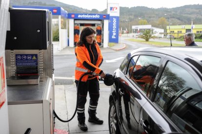 L’empleada d’una estació de servei omple el dipòsit del vehicle d’un client.