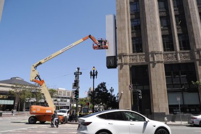 Una grua retira el rètol amb el nou logo de Twitter, ahir.