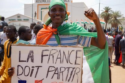 Un manifestant amb un cartell on es llegeix “França se n’ha d’anar”.