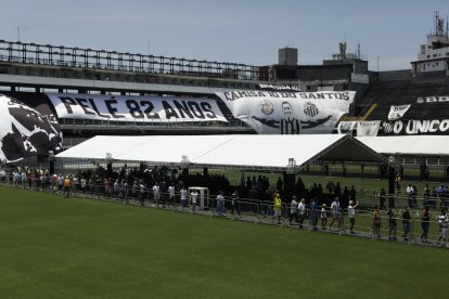 El césped del estadio Vila Belmiro, del Santos, acoge la capilla ardiente de Pelé, ante la que empezó el desfile de miles de aficionados.