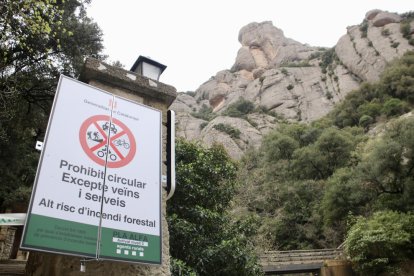 Un cartell senyalitza la prohibició d’accés al Parc Natural de Montserrat pel risc d’incendi.