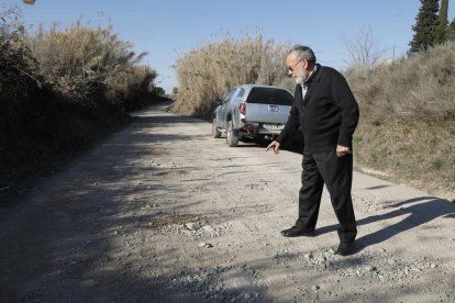 Un veí mostra els clots d’un vial de la partida Camí de la Mariola, ahir.