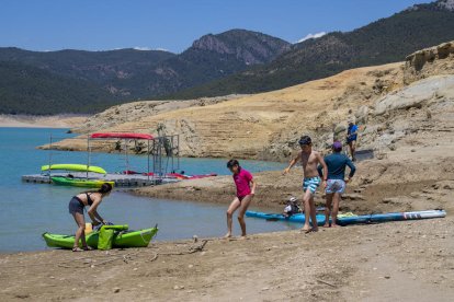 Varios niños jugando al lado del embarcadero del pantano de Canelles.