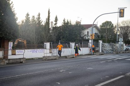 Operarios y una retroexcavadora trabajando ayer en las dos parcelas afectadas por la ampliación.