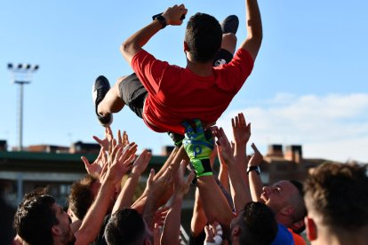 Los jugadores del Alpicat mantean a su entrenador, Edgar Tornero, tras conseguir el ascenso.