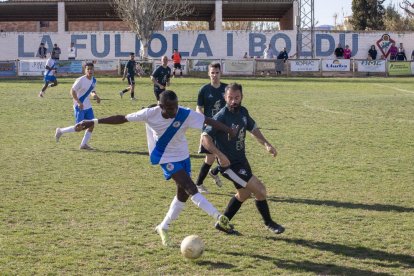 Un jugador local conduce el balón, ante la presión de un oponente del Vallfogona.