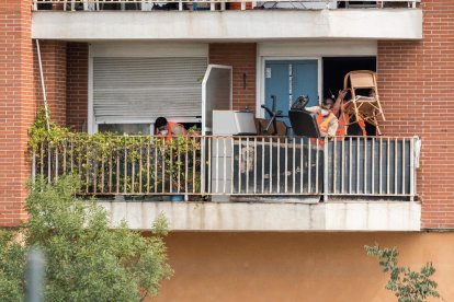 Trabajadores sacan al balcón pertenencias de los okupas.